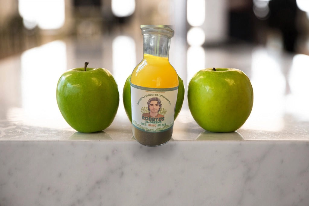 Sweet Mango Splash bottle on a marble counter with fresh green apples
