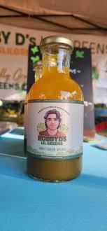 Glass bottle of green microgreens drink on a table at a farmers market stall