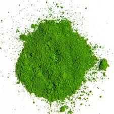 Vibrant green microgreens powder on a white background