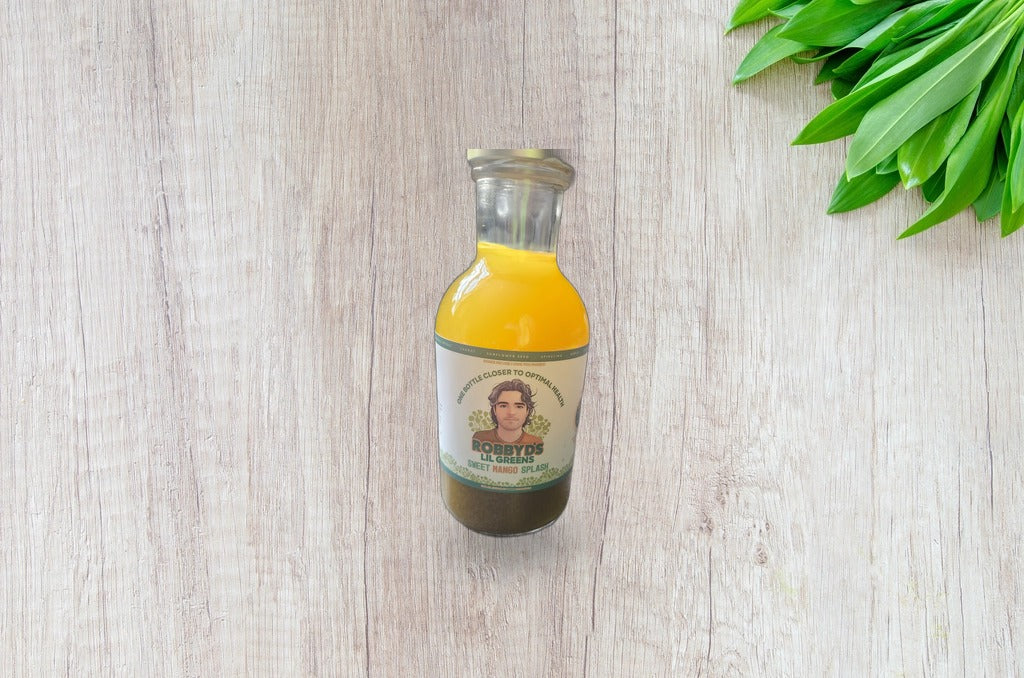 Sweet Mango Splash bottle on a bright wood surface with fresh greens