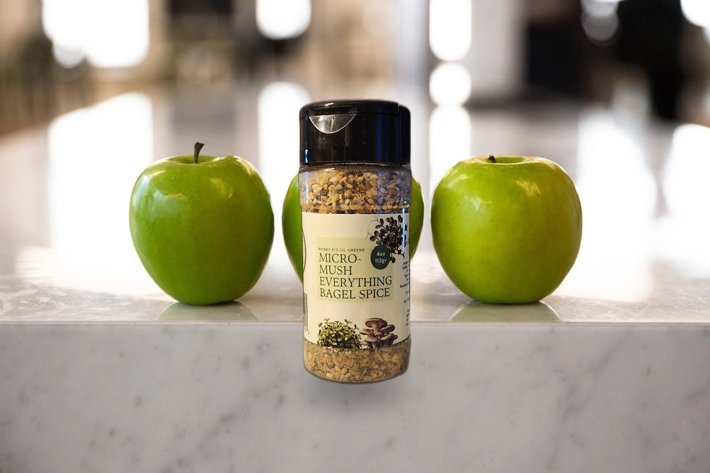 Micro-Mush everything bagel seasoning jar on a marble counter with fresh apples